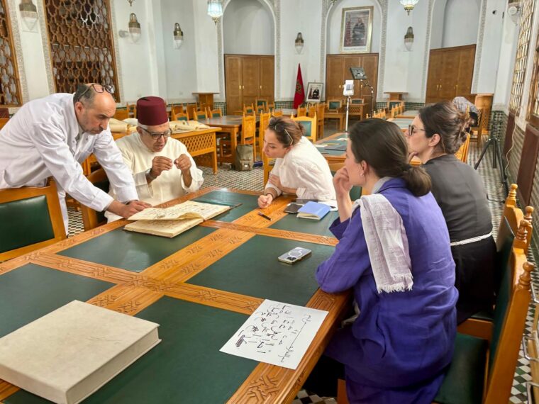 Session de travail sur un manuscrit de la Bibliothèque de la Qarawiyyin à Fès avec le calligraphe Belaïd Hamidi (deuxième en partant de la gauche) et Eloïse Brac de la Perrière, Nuria Garcia Masip et Adeline Laclau (à droite). Crédit : CallFront