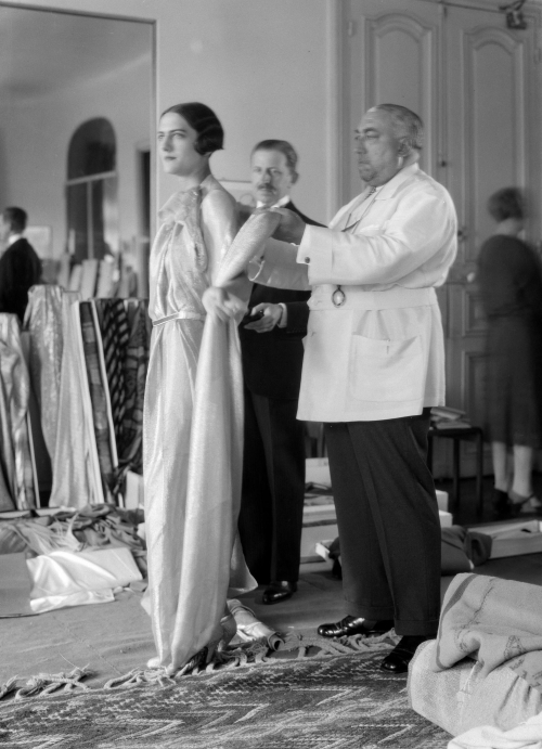 Thérèse Bonney, Paul Poiret photographié avec le mannequin Renée et son tailleur Christian dans les salons de sa maison de couture, 1927, photographie positive par l'ARCP d'après le négatif. © The Bancroft Library, University of California, Berkeley / Thérèse Bonney / BHVP, cote : NN-006-02707. Thérèse Bonney, Paul Poiret photographié avec le mannequin Renée et son tailleur Christian dans les salons de sa maison de couture, 1927, photographie positive par l'ARCP d'après le négatif. © The Bancroft Library, University of California, Berkeley / Thérèse Bonney / BHVP, cote : NN-006-02707.